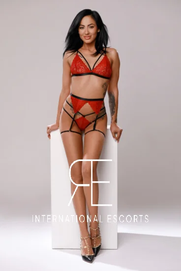 A London escort dressed in red lingerie and black stilettos 