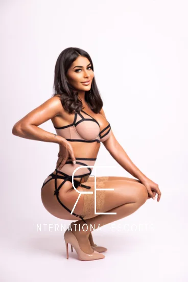 Brunette London escort Nour looks very sexy in black and cream lingerie 