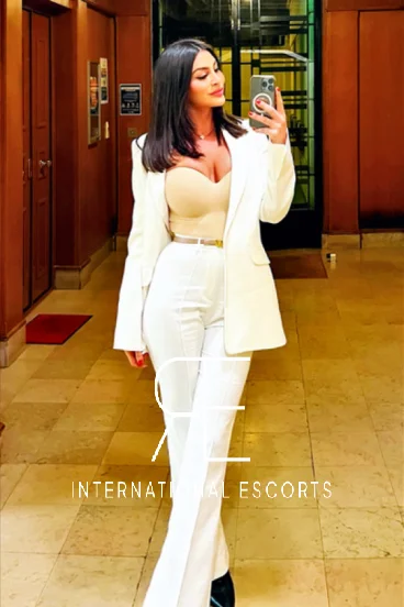 A tall french escort in a white trouser suit 