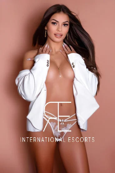 London escort Villa is wearing a white blazer with nothing on underneath 