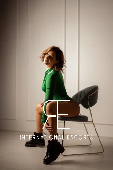 London escort Nyla is sitting in a chair with her legs spread 