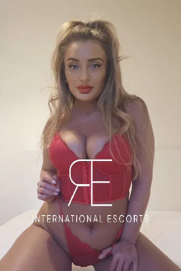 Blonde escort Bambi looks sexy in red with red lips 