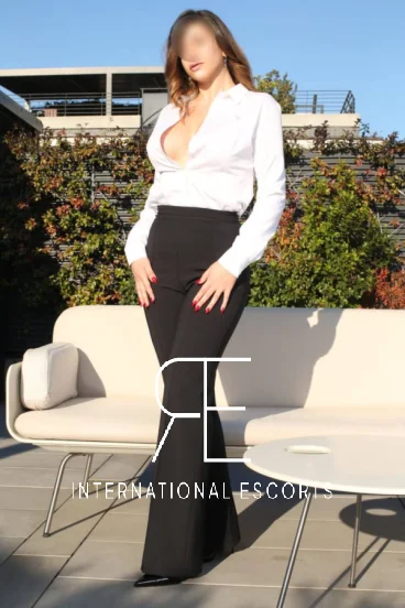 Elegant Italian escort Frankie is wearing black trousers and a white blouse in this pictrue 