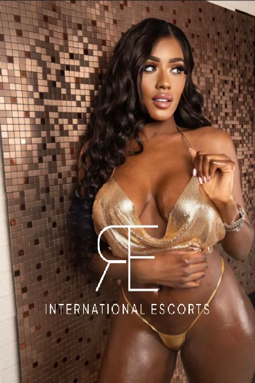 A very sexy Ebony escort in London is pictured in a tiny gold thong 