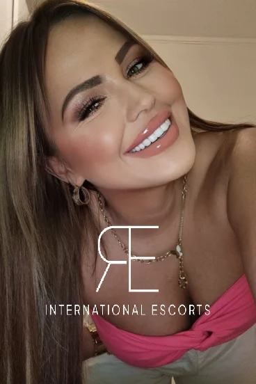 A very sexy London escort is smiling at the camera 