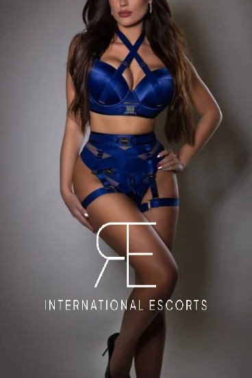 Rose looks very sexy dressed in blue lingerie and sanding with her hand on her hip 