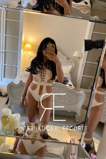 A brunette London escort took this selfie of her standing by the end of her bed 