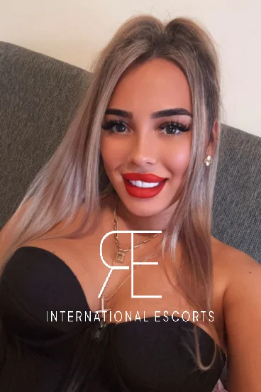 A beautiful blonde Eastern European London escort with bright red lips 