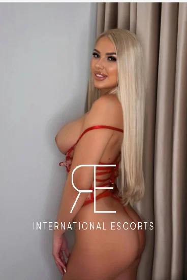 Blonde escort wearing strappy red lingerie 