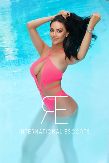 A London escort lady standing in a swimming pool 