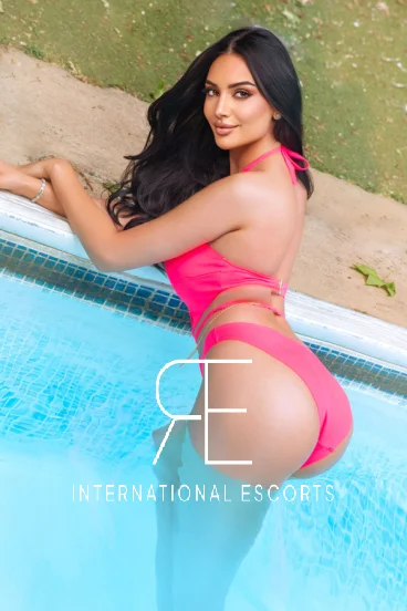 Andi is bent over the edge of a swimming pool to show off her arse 