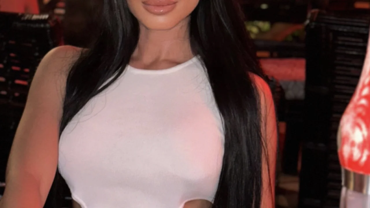 A selfie of a sexy brunette lady with blowjob lips holding a cocktail 