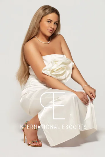 A sexy blonde lady wearing a white dress and strappy high heels 