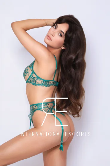 Slim young lady with long brown hair wearing green lingerie 