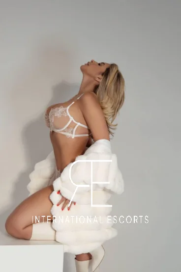 Female London posing posing for a photo wearing a white fur coat 