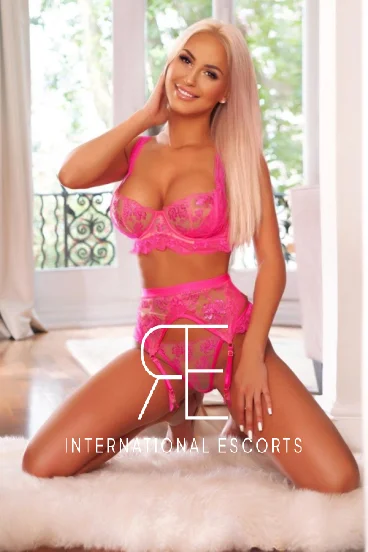 Mature blonde London escort wearing pink lingerie 