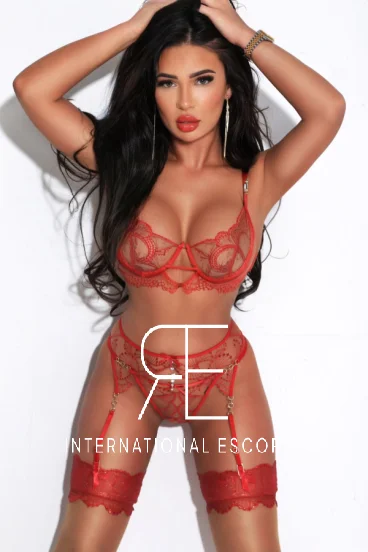 Busty brunettte lady with bright red lips wearing red lingerie 