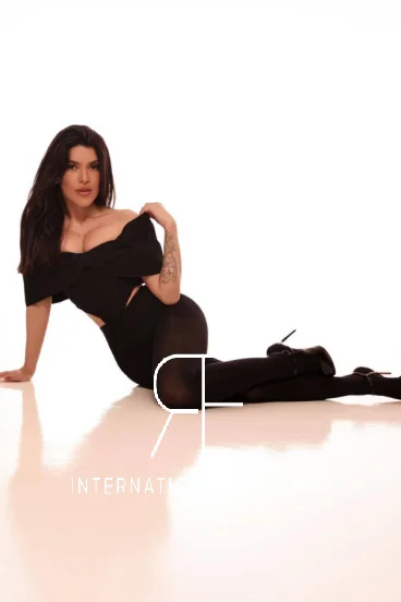Lady wearing an off the shoulder top sitting on the floor 
