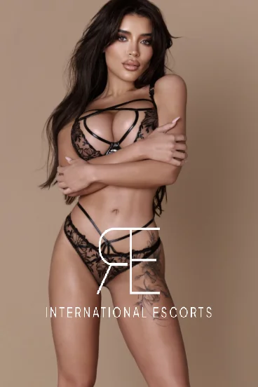 Tornia wears bold black lingerie, sculpted curves and ink giving international goddess energy.