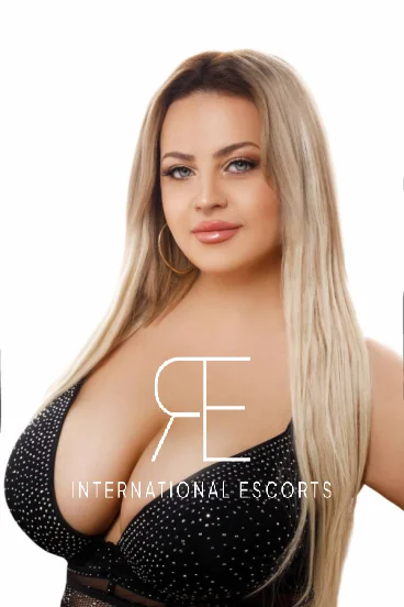 Gorgeous blonde Alenka close-up in glittering black lingerie, radiant smile.