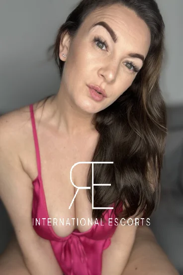 Pink lingerie close-up of Lucy Rose, sensual gaze paired with her flawless cleavage.