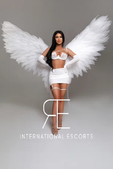 Brunette London escort in angel wings and white lingerie