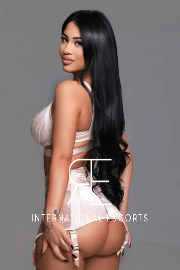 Brunette London escort in pale pink lingerie, rear shot
