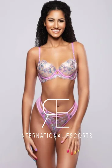 Gigi, tall ebony model in pastel lingerie smiling warmly