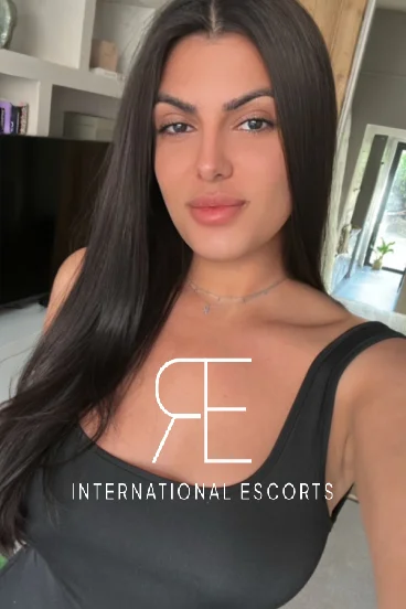 Cleo close-up selfie in black top, glamorous travel companion