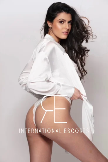 Side profile of Cleo in silk shirt and white lace lingerie