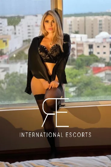 Stylish Brazilian escort Mara in lingerie by window, West Kensington incall