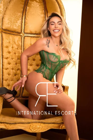 Alluring Lainey in vibrant green corset, smiling with elegance