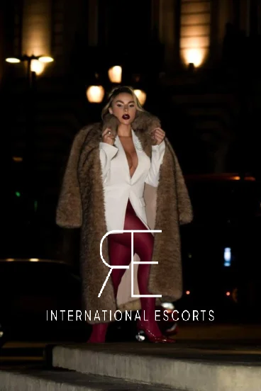 Lainey walking confidently in blazer, tights and coat