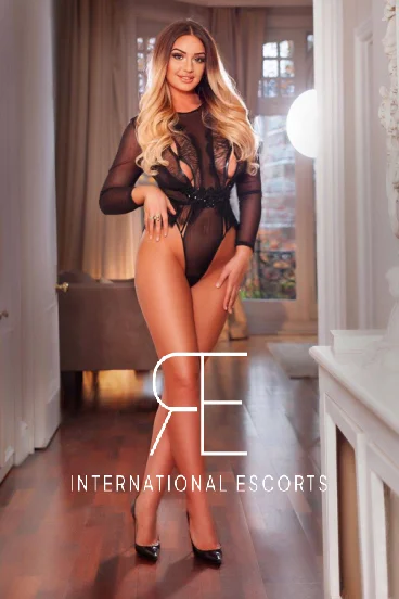 Tall Marylebone beauty Caprice in chic black lingerie, travel-ready allure
