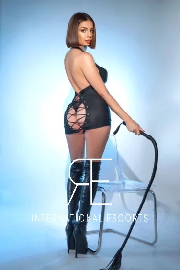 Angelica, sophisticated dominatrix beauty, confident in black mini dress