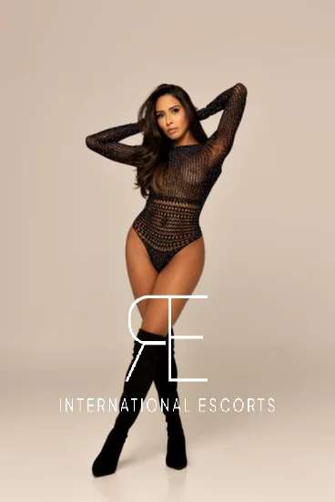 Clemmie in sheer black bodysuit, tall boots, international escort London
