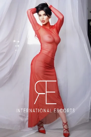 Rosaline, sophisticated in sheer red gown, international escort allure