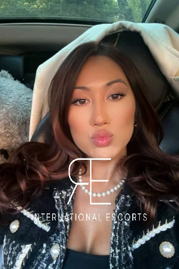 High class Asian London escort sitting in a car taking a selfie