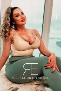 A profile picture of a busty London escort named Maci 